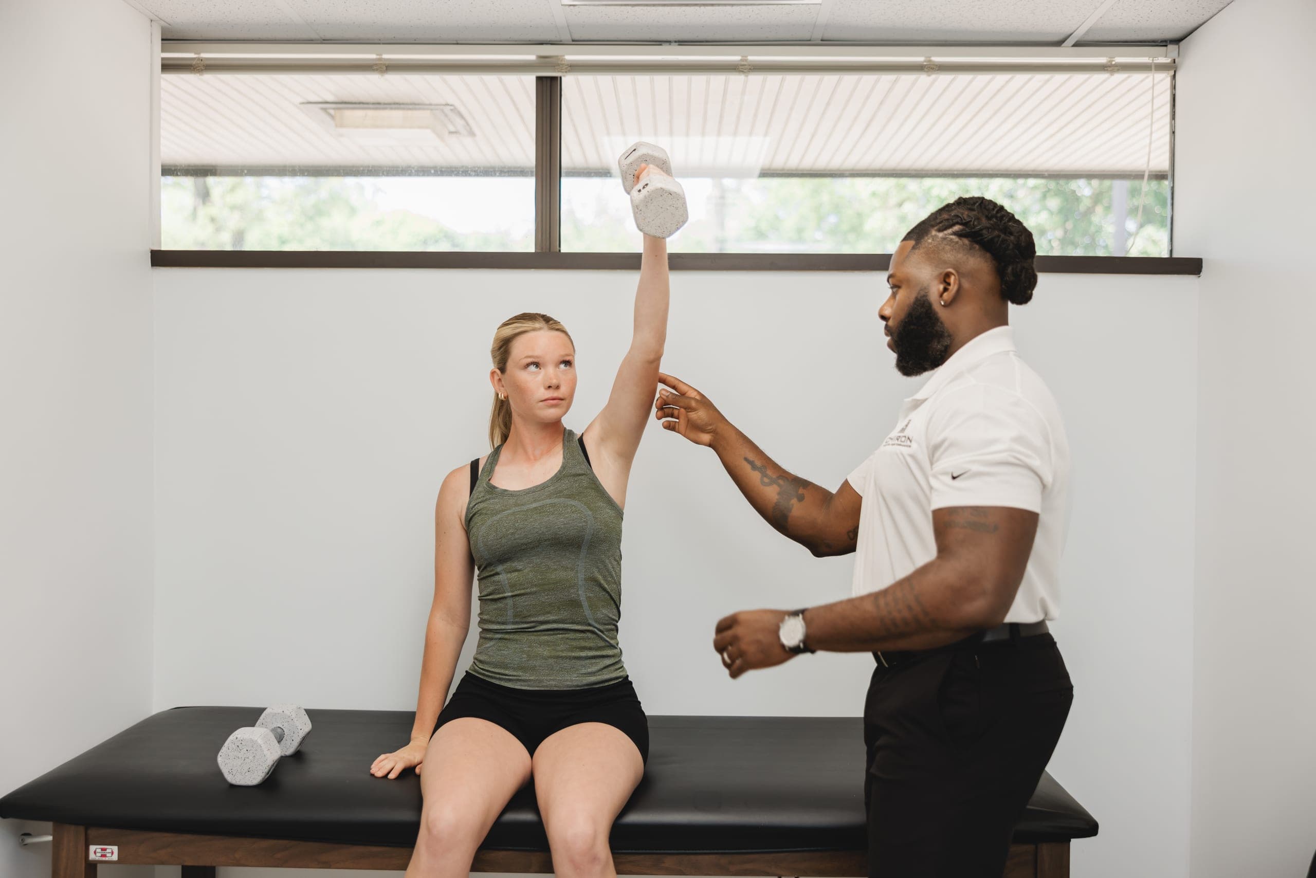 Dr. Ohanaja coaching athlete through shoulder strength assessment