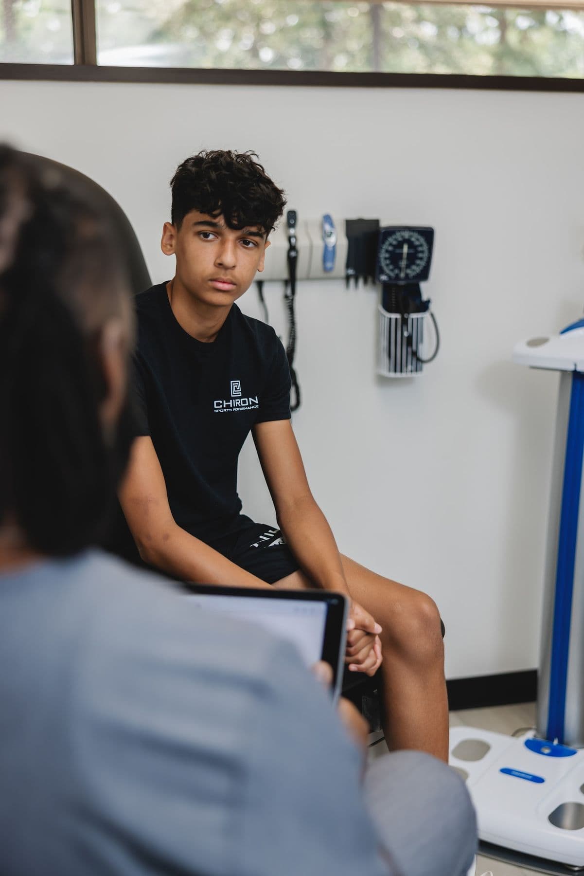A young athlete in a Chiron exam room during a physician visit